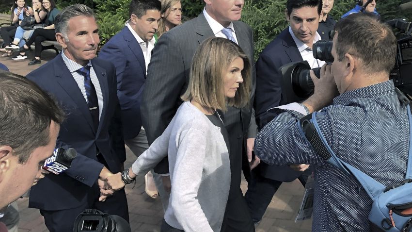Lori Loughlin depart federal court with her husband, clothing designer Mossimo Giannulli, left, on Tuesday, Aug. 27, 2019, in Boston, after a hearing in a nationwide college admissions bribery scandal. (AP Photo/Philip Marcelo)