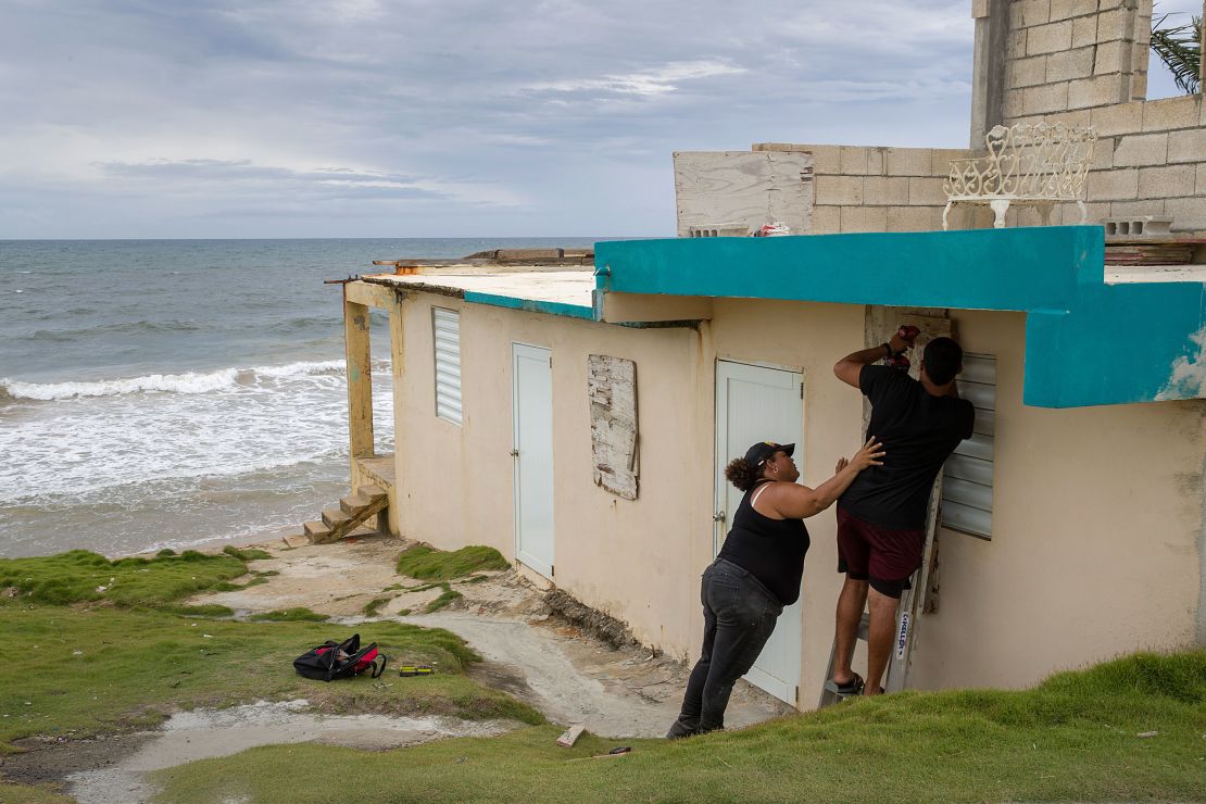 Ya Mary Morales, left, and Henry Sustache put plywood over the windows of their home Wednesday morning in Yabucoa, Puerto Rico, ahead of Dorian.