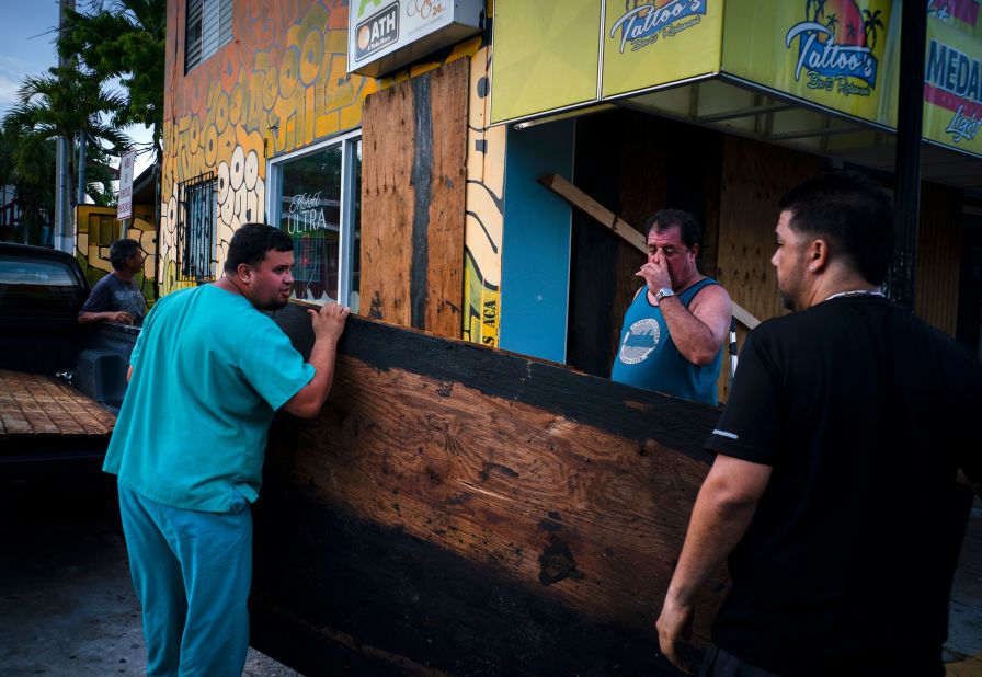 Men board up a shop's windows in Boqueron, Puerto Rico, on August 27.