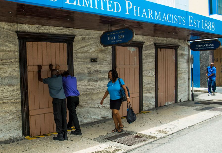 Residents board up a storefront pharmacy in Bridgetown, Barbados, on Monday, August 26.