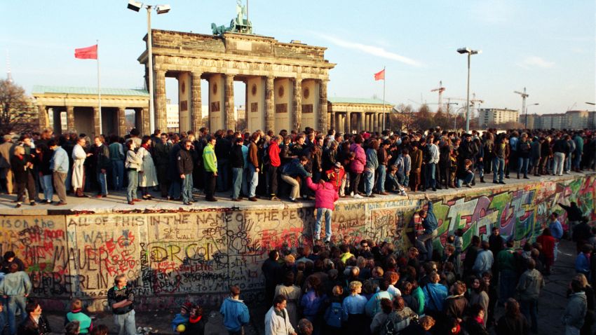 People climbing on the Berlin Wall at the Brandenburg Gate shortly after its opening