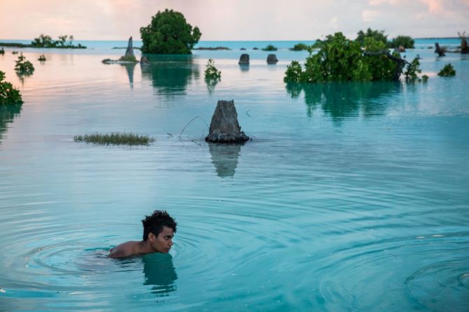 Peia Kararaua, 16, swims in a flooded area of Kiribati's Aberao village. Kiribati is one of the countries most affected by sea-level rise, photographer <a href="index.php?page=&url=http%3A%2F%2Fwww.vladsokhin.com%2F" target="_blank" target="_blank">Vlad Sokhin</a> said. During high tides many villages become inundated, making large parts of them uninhabitable. This photo was taken in an area that, when dry, is a soccer field. "Prior to this, a man moved his vehicle from the lower part of the field to the higher point, and the vehicle ended up being parked on an 'island' when the water came," Sokhin said. "Young people started swimming there and playing when I took this shot. It was strange to see such a scene: happy kids swimming along the remains of the dead palm trees."