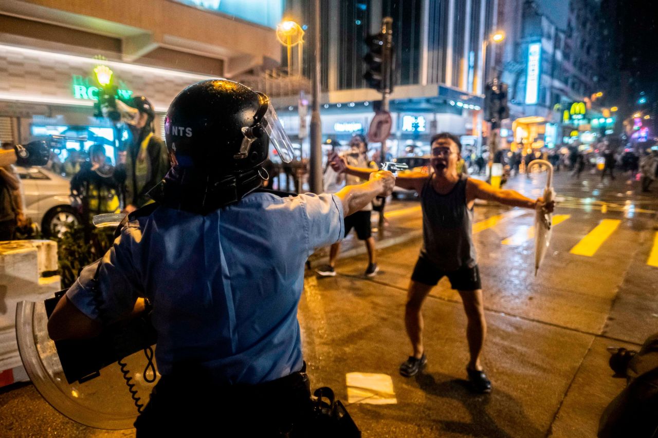 A police officer raises a pistol at a protester during demonstrations in <a href="https://www.cnn.com/2019/06/09/world/gallery/hong-kong-extradition-protest/index.html" target="_blank">Hong Kong</a>, on Sunday, August 25. The night was one of the most violent since <a href="https://www.cnn.com/2019/08/25/asia/hong-kong-protest-aug-25-intl-hnk/index.html" target="_blank">the protests</a> began 12 weeks ago.