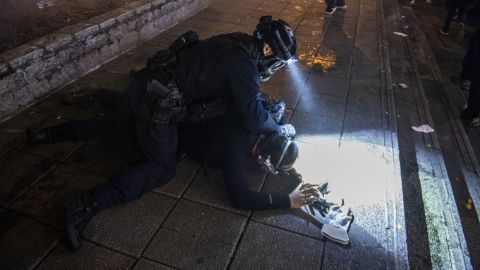 A police officer from the Special Tactical Squad, nicknamed the "raptors," arrests a protester on August 11.