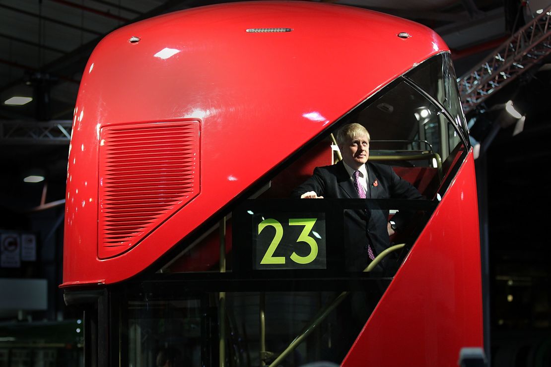 Boris Johnson stands at the back of a Routemaster.