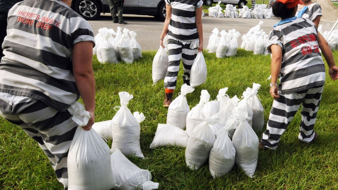 A supervised work crew of female jail prisoners fills sandbags in Titusville, Florida, on Thursday, August 29.