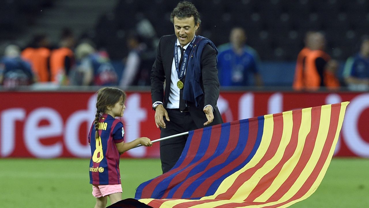 Barcelona's coach Luis Enrique and his daughter Xana wave a flag after the UEFA Champions League Final football match between Juventus and FC Barcelona at the Olympic Stadium in Berlin on June 6, 2015. FC Barcelona won the match 1-3.        AFP PHOTO / LLUIS GENE        (Photo credit should read LLUIS GENE/AFP/Getty Images)
