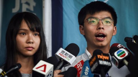 Pro-democracy activists Agnes Chow and Joshua Wong speak to the media after they were released on bail at the Eastern Magistrates Courts on Friday, August 30. They were arrested earlier the same day in a dragnet across Hong Kong.