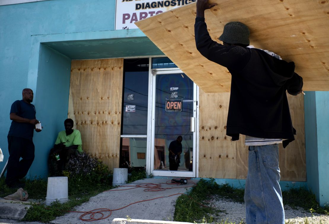 Workers board up a shop's window front as they make preparations for the arrival of Hurricane Dorian in Freeport on August 30.