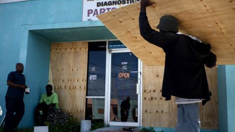 Workers board up a shop's window front as they make preparations for the arrival of Hurricane Dorian in Freeport on August 30.