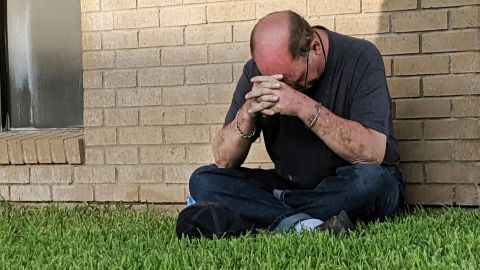 A man prays outside of the Medical Center Hospital Emergency room in Odessa, Texas, on Saturday.