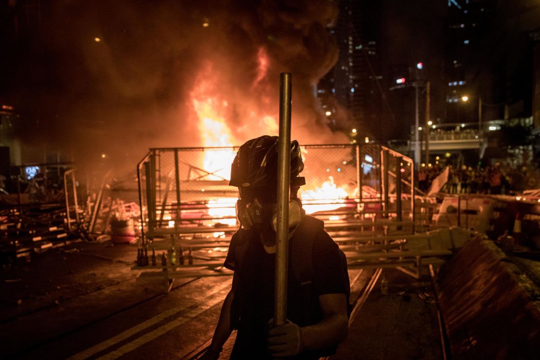 A protesters walks in front of a burning barricade after clashing with police at an anti-government rally on August 31, 2019 in Hong Kong.