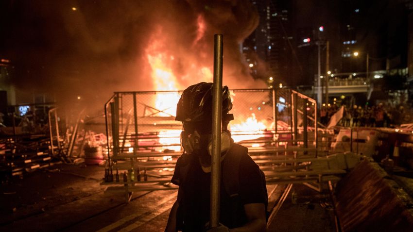HONG KONG, CHINA - AUGUST 31: A protesters walks in front of a burning barricade  after clashing with police at an anti-government rally on August 31, 2019 in Hong Kong, China. Pro-democracy protesters have continued rallies on the streets of Hong Kong against a controversial extradition bill since 9 June as the city plunged into crisis after waves of demonstrations and several violent clashes. Hong Kong's Chief Executive Carrie Lam apologized for introducing the bill and declared it "dead", however protesters have continued to draw large crowds with demands for Lam's resignation and completely withdraw the bill.  (Photo by Chris McGrath/Getty Images)