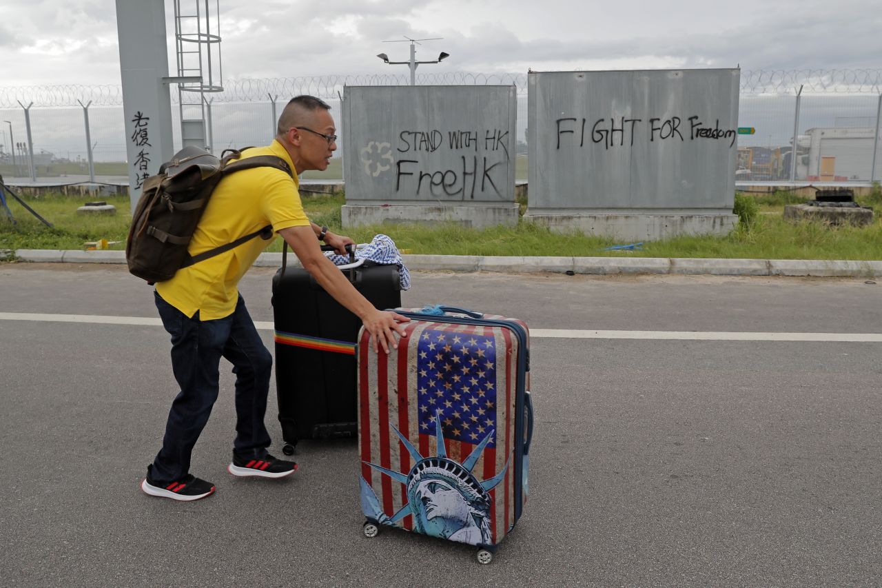 A passenger walks to the airport on September 1 as pro-democracy protesters blocked a road outside the airport.
