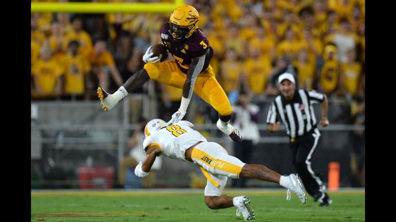 Arizona State Sun Devils running back Eno Benjamin hurdles Kent State safety Elvis Hines during the first half of their NCAA football game at Sun Devil Stadium in Tempe, Arizona, on Thursday, August 29.