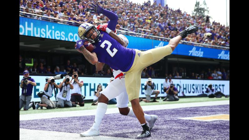 Aaron Fuller of the Washington Huskies completes a catch for a touchdown while defended by Darreon Moore of the Eastern Washington Eagles during the first quarter of an NCAA football game in Seattle, Washington, on August 31.