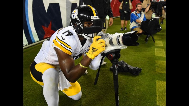 Pittsburgh Steelers wide receiver JuJu Smith-Schuster celebrates with a media member's camera after scoring a touchdown during the first half of an NFL pre-season game against the Tennessee Titans at Nissan Stadium in Nashville, Tennessee, on August 25.