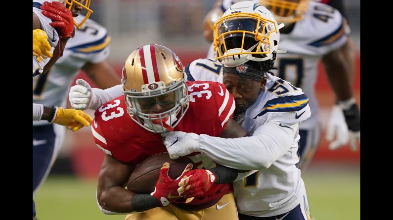 Jatavis Brown of the Los Angeles Chargers loses his helmet while tackling Austin Walter of the San Francisco 49ers during the first quarter of an NFL game at Levi's Stadium in Santa Clara, California, on August 29.