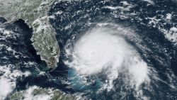This GOES-16 satellite image taken Sunday, Sept. 1, 2019, at 17:00 UTC and provided by National Oceanic and Atmospheric Administration (NOAA), shows Hurricane Dorian, right, churning over the Atlantic Ocean. Hurricane Dorian struck the northern Bahamas on Sunday as a catastrophic Category 5 storm, its 185 mph winds ripping off roofs and tearing down power lines as hundreds hunkered in schools, churches and other shelters. (NOAA via AP)