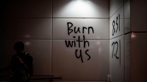 Graffiti outside Hong Kong's Tung Chung subway station reads "burn with us."