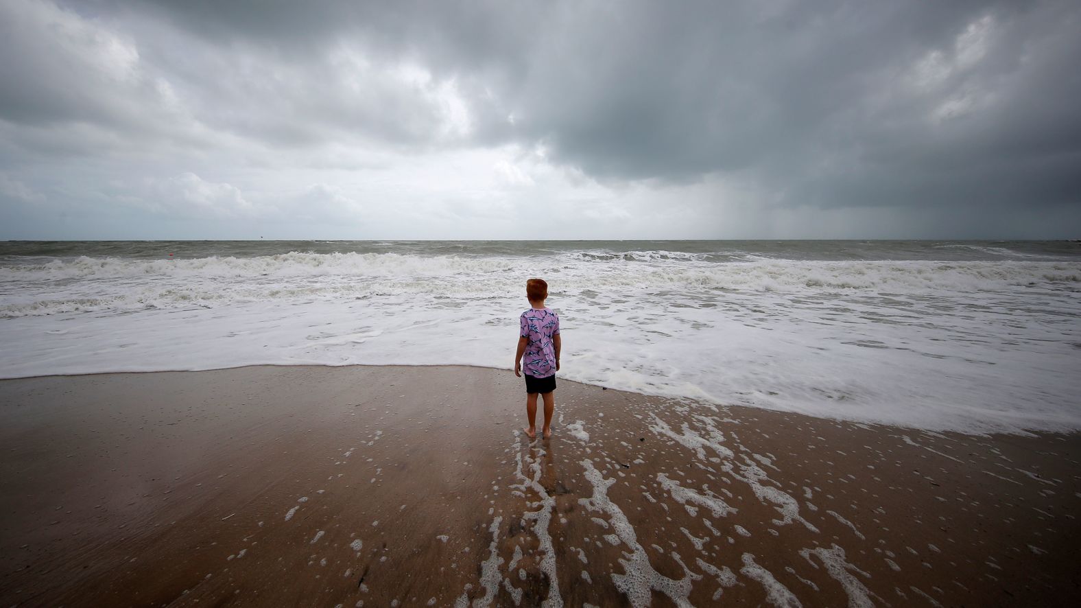 A boy stands near high surf in Vero Beach, Florida, on September 2.