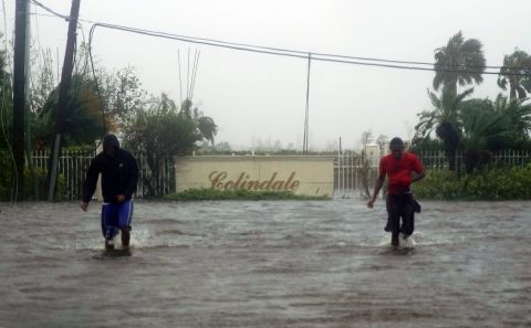 Residents wade through a flooded street in Freeport on September 3.