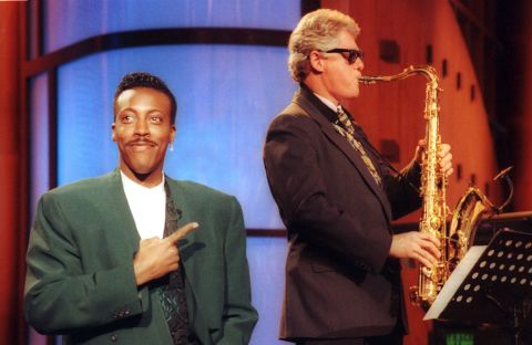 Talk show host Arsenio Hall gestures approvingly as Clinton plays the saxophone during a taping of 