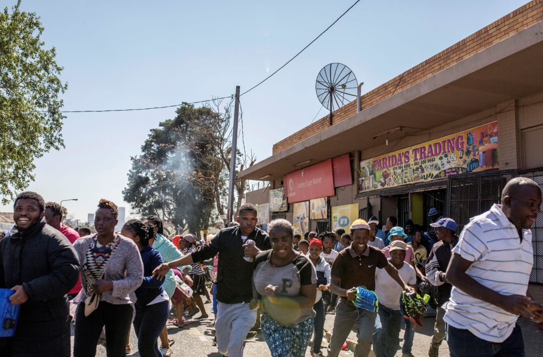 Looters run off an alleged foreign-owned shop in Turffontein in Johannesburg on Monday. 