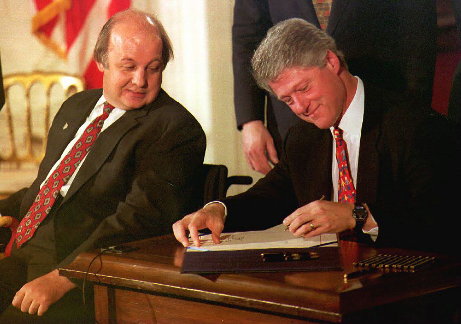 James Brady, the Reagan administration press secretary who was wounded during a 1981 assassination attempt, watches Clinton sign the Brady Bill at the White House in November 1993. The bill required a five-day waiting period for handgun purchases.