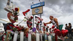 EL PASO, TEXAS - AUGUST 06:  A woman touches a cross at a makeshift memorial for victims outside Walmart, near the scene of a mass shooting which left at least 22 people dead, on August 6, 2019 in El Paso, Texas. A 21-year-old white male suspect remains in custody in El Paso, which sits along the U.S.-Mexico border. President Donald Trump plans to visit the city August 7. (Photo by Mario Tama/Getty Images)