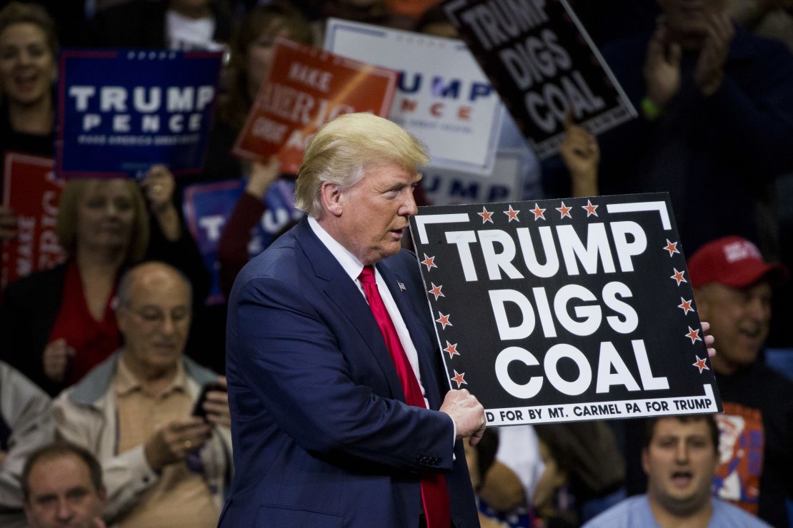Then-Republican presidential nominee Donald Trump holds a sign supporting coal at a 2016 rally. As president, Trump's administration has eased many regulations meant to stop climate change.