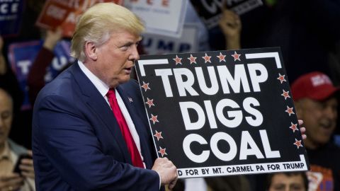 Then-Republican presidential nominee Donald Trump holds a sign supporting coal during a rally in Pennsylvania on October 10, 2016. President Trump's moves to gut greenhouse gas regulations were applauded by many in the fossil fuel industry, but coal jobs continued to decline on his watch.