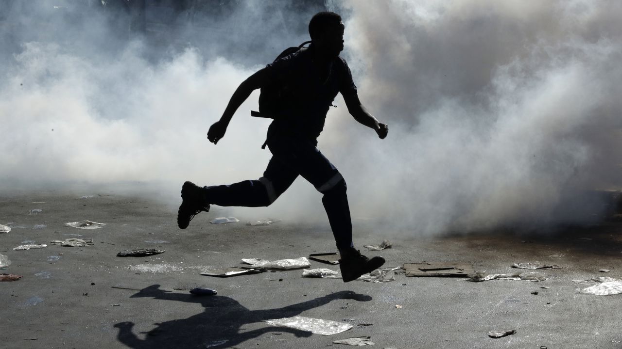 A man runs from tear gas in Germiston, east of Johannesburg, South Africa.
