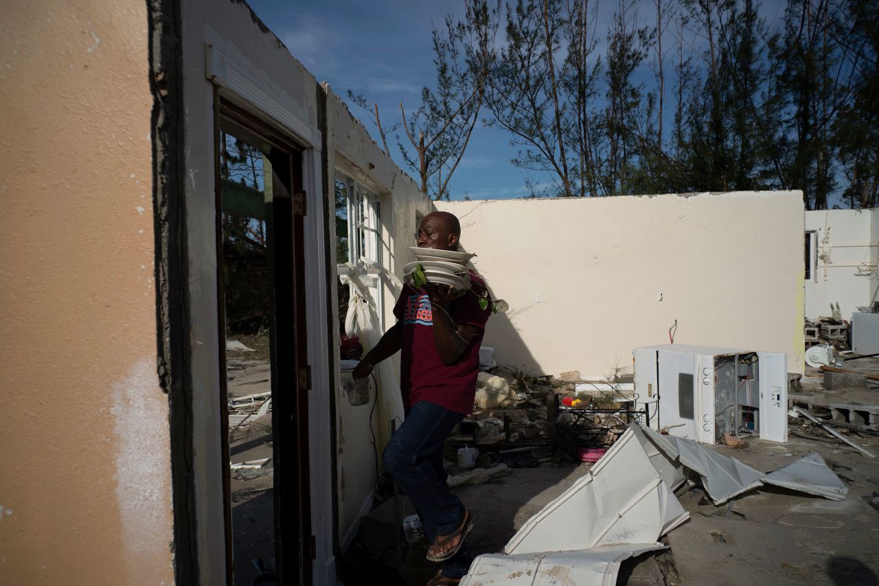 A resident recovers dishes from his son's home in Pine Bay, Bahamas, on September 4.