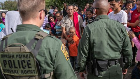 LOS EBANOS, TEXAS - JULY 02: U.S. Border Patrol agents watch over immigrants after taking them into custody on July 02, 2019 in Los Ebanos, Texas. Hundreds of immigrants, most from Central America, turned themselves in to border agents after rafting across the Rio Grande from Mexico to seek political asylum in the United States.  (Photo by John Moore/Getty Images)