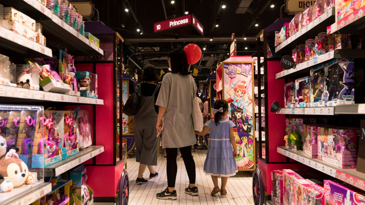 Customers walk past a toy display in South Korea, on September 3, 2017.