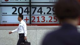 A man walks past an electronic stock board showing Japan's Nikkei 225 index at a securities firm in Tokyo Tuesday, Aug. 27, 2019. Asian shares mostly rose Tuesday as investors found reason to be cautiously optimistic again about the potential for progress in the costly trade war between the U.S. and China. (AP Photo/Eugene Hoshiko)