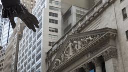 The hand from the George Washington statue at Federal Hall stands in front of the New York Stock Exchange (NYSE) in New York, U.S., on Thursday, Aug. 4, 2016. U.S. stocks fluctuated, as investors looked past increased stimulus by the Bank of England to Friday's jobs report for clues on the strength of the economy and the Federal Reserve's next moves. Photographer: Victor J. Blue/Bloomberg via Getty Images