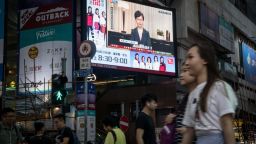 HONG KONG, CHINA - SEPTEMBER 04: People walk past a big screen replaying Hong Kong Chief Executive Carrie Lam  announcing the formal withdrawal of the extradition bill on September 04, 2019 in Hong Kong, China. Hong Kong's embattled leader Carrie Lam announced the formal withdrawal of the controversial extradition bill on Wednesday, meeting one of protesters' five demands after 13 weeks of demonstrations which became the biggest political crisis since Britain handed its onetime colony back to China in 1997. (Photo by Chris McGrath/Getty Images)