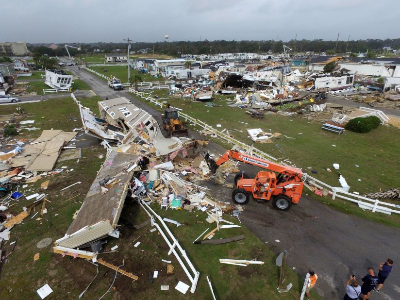 Emerald Isle employees work to clear a road after a tornado hit.