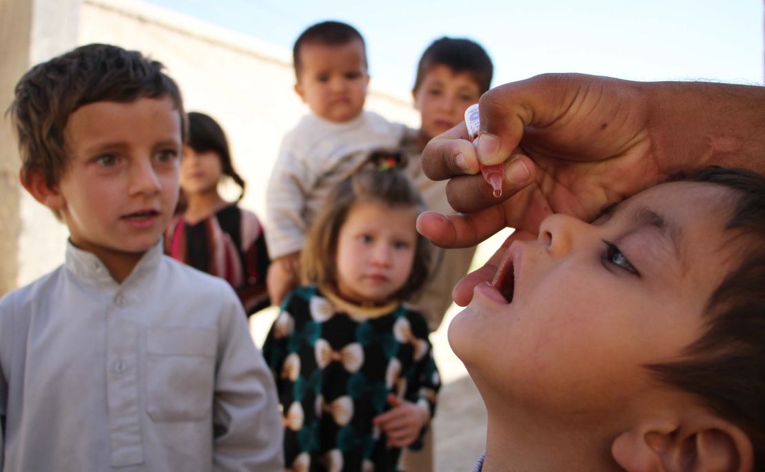  A health worker administers a polio vaccine to a child in Afghanistan in 2017. Afghanistan and Pakistan are the only countries in the world where the disease is endemic.