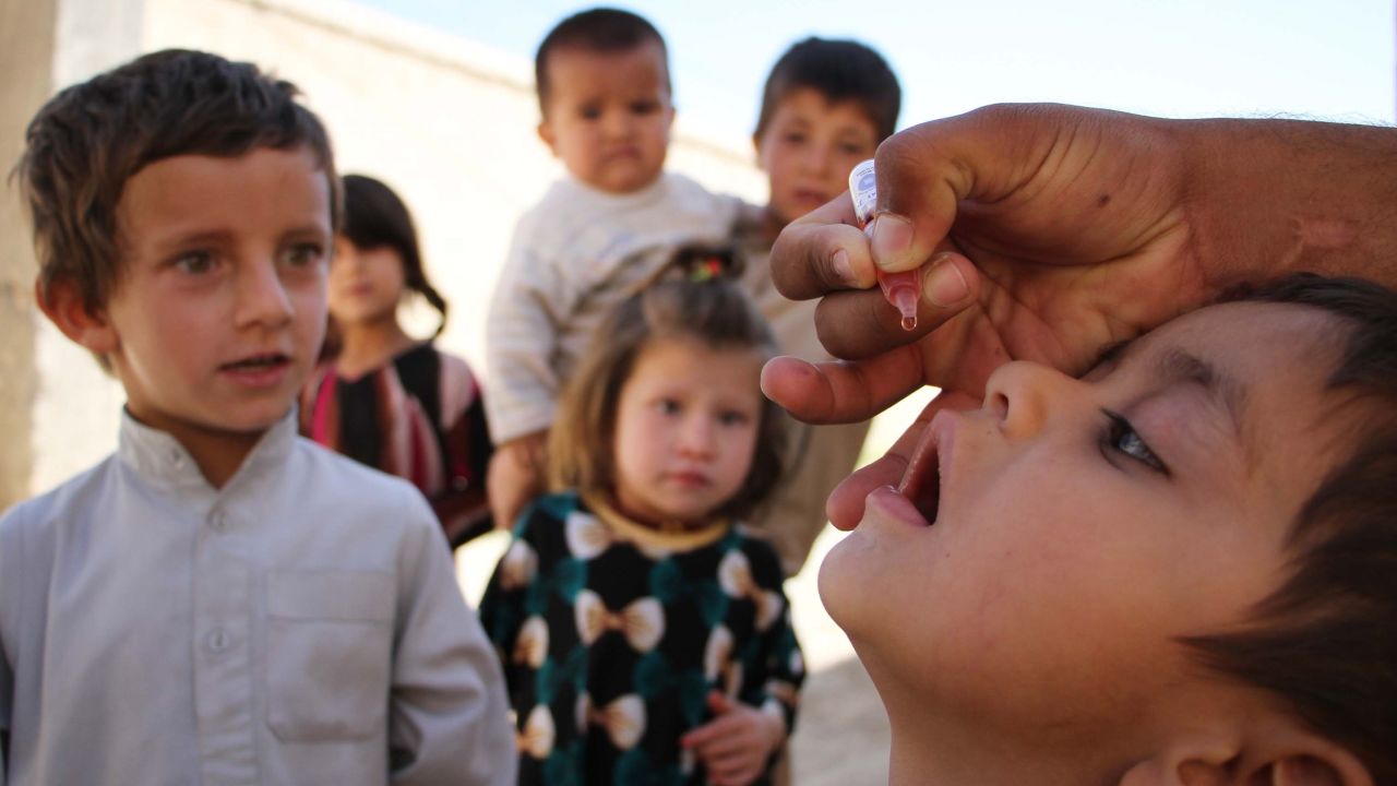  A health worker administers a polio vaccine to a child in Afghanistan in 2017. Afghanistan and Pakistan are the only countries in the world where the disease is endemic.