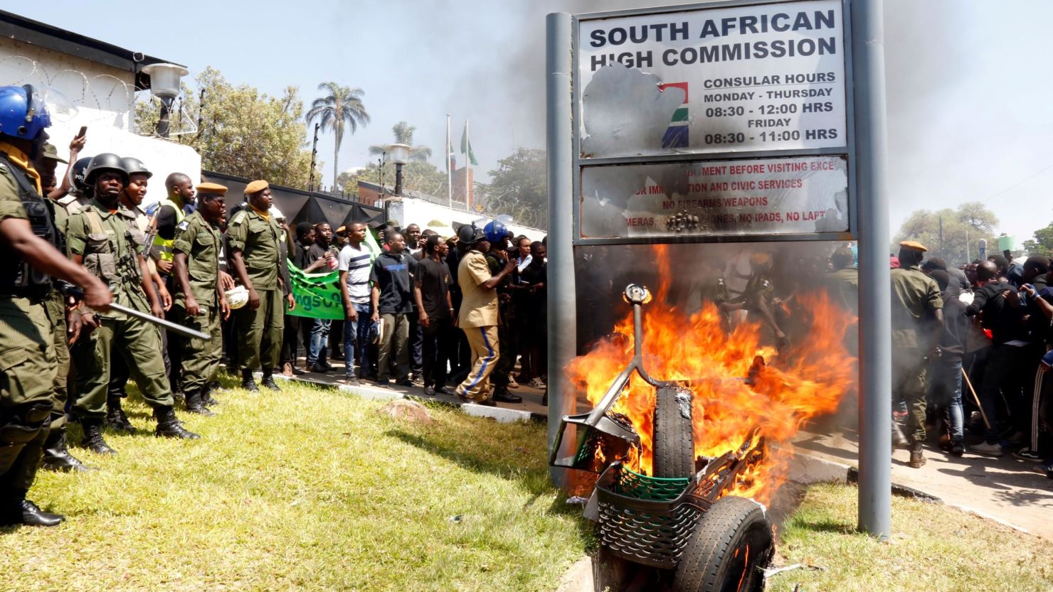 Zambia's university students burn the sign outside the South African Embassy in Lusaka on September 4, 2019 during a demonstration to protest against xenophobic attacks on foreign nationals in the Rainbow Nation. (Photo by SALIM DAWOOD / AFP) 