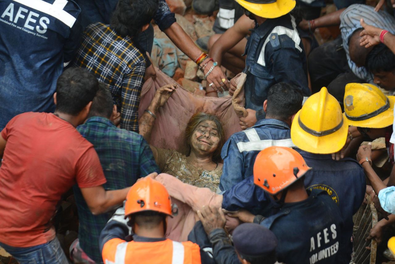 Ahmedabad Fire and Emergency services personnel rescue a woman after a residential building collapsed in Ahmedabad, India, on Thursday, September 5.<br />