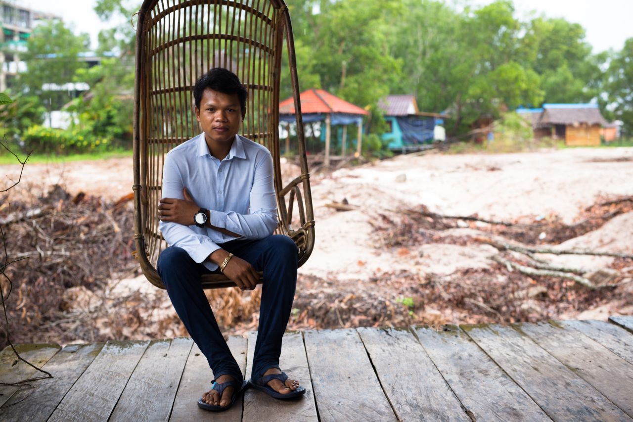 Sina, the son-in-law of Sok Sabay Resort's owner, sits on a veranda that used to look out onto a pretty pond. It has now been filled out to make way for a construction site.