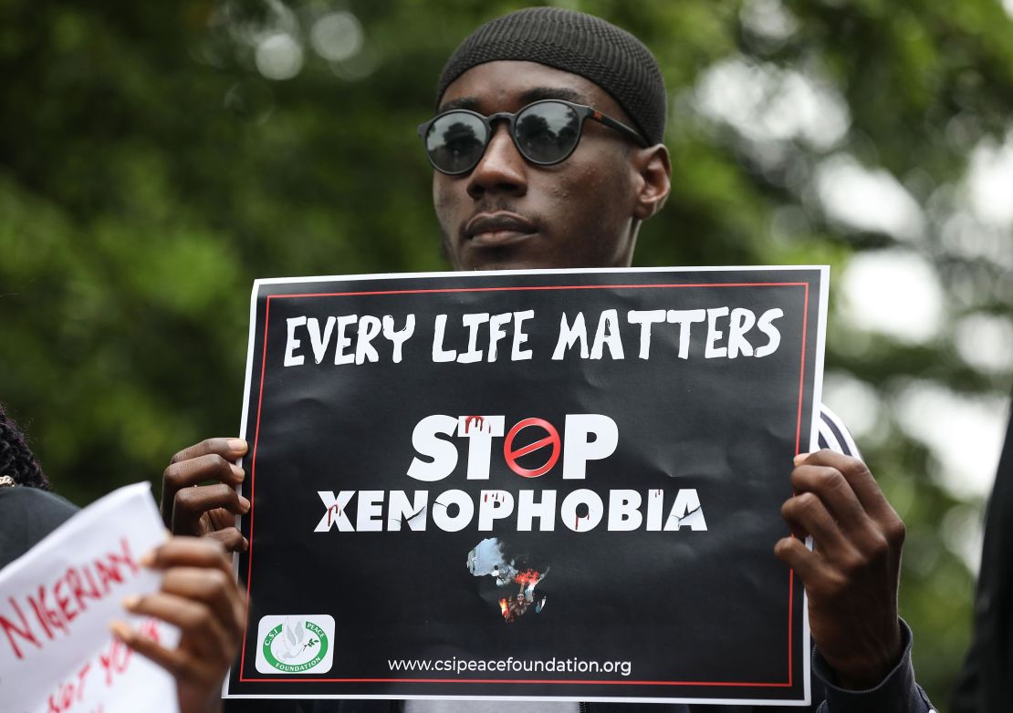 A demonstrator holds a sign during a protest against xenophobia outside of the main gate of the South African High Commission in Abuja, Nigeria.