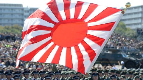 A soldier holds a Rising Sun flag during the military review at the Ground Self-Defence Force's Asaka training ground on October 27, 2013. 
