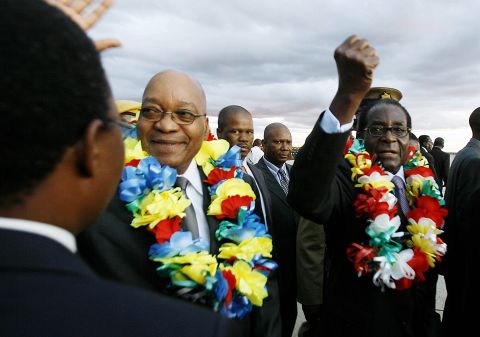 South African President Jacob Zuma walks with Mugabe at Harare International Airport in March 2010.