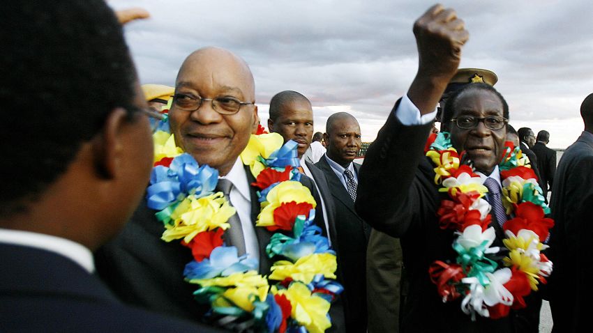 South African President Jacob Zuma (L) and Zimbabwean counterpart Robert Mugabe are seen at Harare International Airport on March 16, 2010. President Jacob Zuma arrived in Zimbabwe for fresh talks aimed at easing tensions within the year-old unity government.  President Robert Mugabe and Prime Minister Morgan Tsvangirai both greeted him at the airport, in a rare joint appearance by the feuding leaders. The rivals formed a unity government in February last year under stiff international pressure, aiming to end an economic freefall and curb deadly political violence after disputed presidential elections in 2008. AFP PHOTO/Desmond Kwande (Photo credit should read DESMOND KWANDE/AFP/Getty Images)