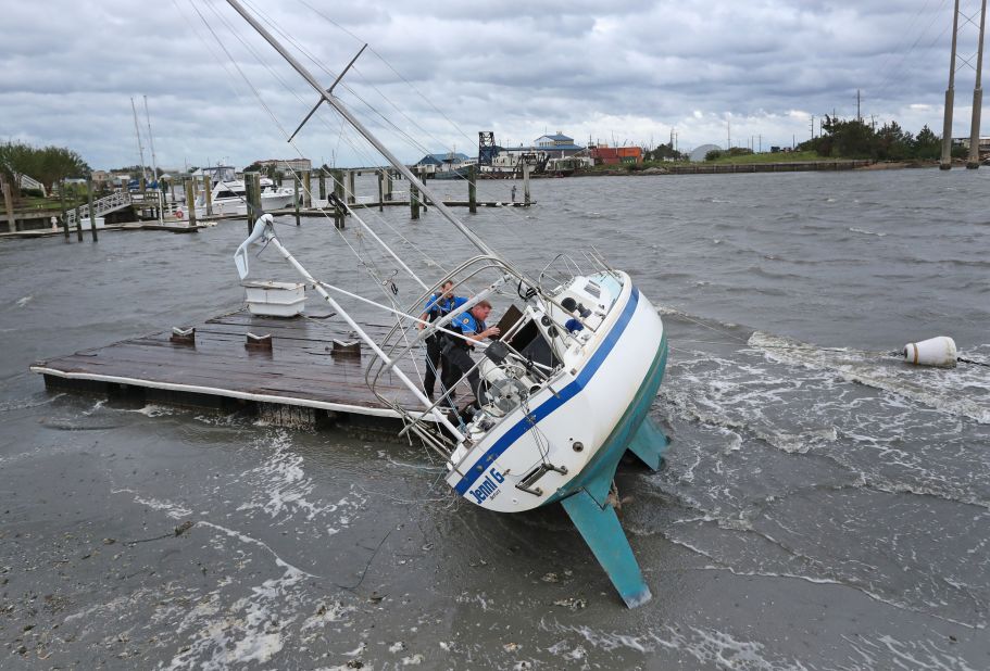 Police Officer Curtis Resor, left, and Sgt. Michael Stephens check a sailboat for occupants in Beaufort, North Carolina, on September 6.